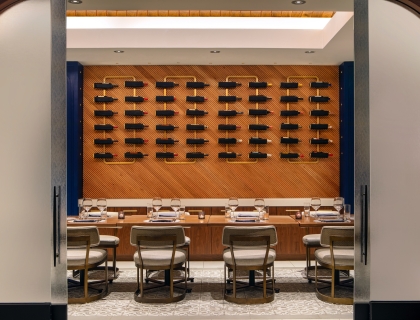 a private dining area with various bottles of wine on the wall